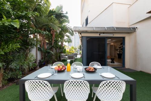 a table and chairs on the patio of a building at O&O Group - Huge Villa With Jacuzzi By The Beach in Rishon LeẔiyyon