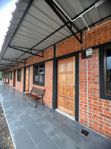 a bench sitting under awning on a brick building at Ujud Sepakat Homestay in Melaka