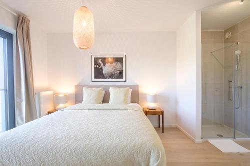 Schlafzimmer mit einem weißen Bett und einer Glasdusche in der Unterkunft Lumineux Appartement 1 chambre proche Ecole Européenne in Brüssel