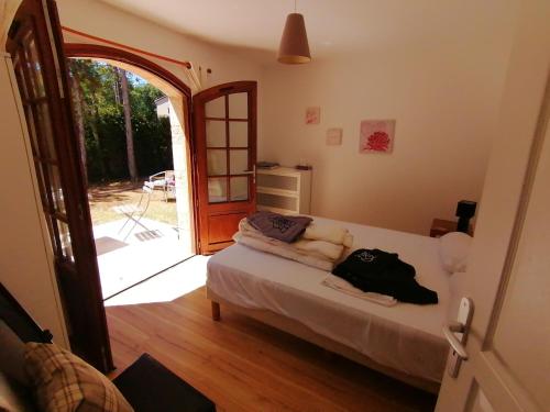 a bedroom with a bed and an open door at Villa Lilas in Doumen