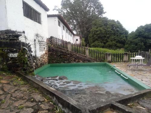 a swimming pool in the yard of a house at Pouso do Tropeiro - Cavalgadas Roseta in Baependi