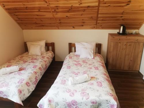 two beds sitting next to each other in a room at Pensjonat Rosochate Wzgórze in Rosochaty Róg