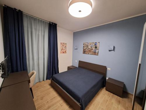 a bedroom with a blue bed and a window at Casa Mirò in Parma