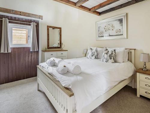 a bedroom with a large white bed with towels on it at Chapel Barn in Bolnhurst