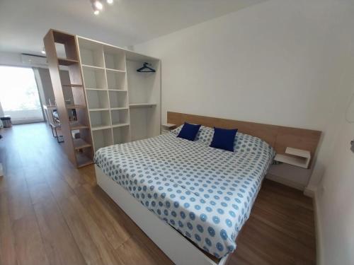1 dormitorio con 1 cama grande con almohadas azules en Apart Cid Campeador en Buenos Aires