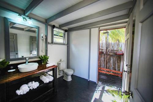 bagno con lavandino, servizi igienici e specchio di Conch Beach Cabins 