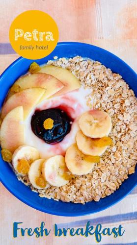 a blue plate of food with bananas and eggs and oats at Petra Hotel in Petrich