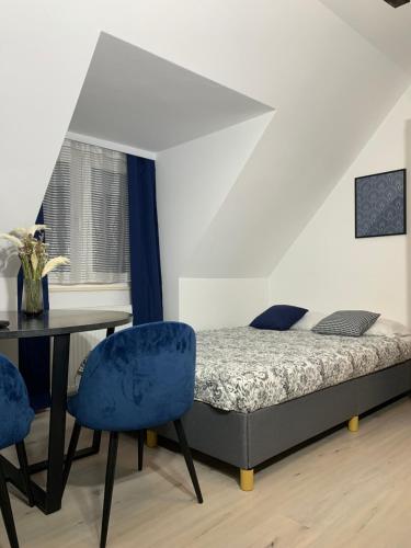 a bedroom with a bed and a table and chairs at Zacisze Nest - noclegi blisko plaży in Mielno