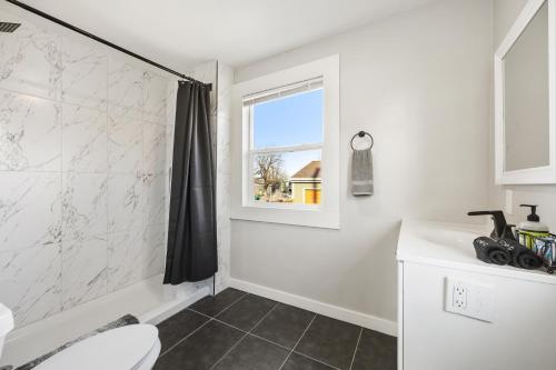 a bathroom with a toilet and a window at Peaceful Home w/ 4BR, Big Yard and amazing art in Denver