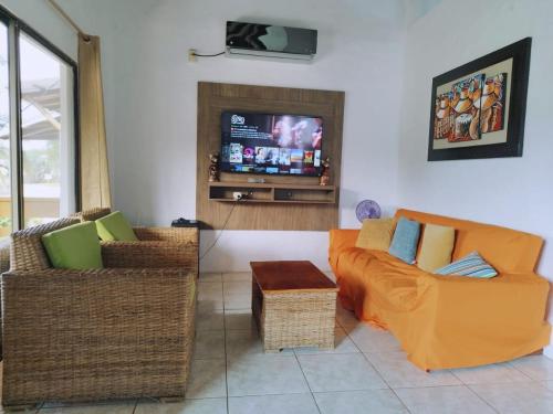 uma sala de estar com um sofá e uma televisão em La Cabaña de Victor em Olón