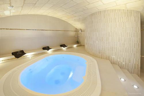 a bathroom with a large blue tub in a room at Hôtel de Sèze & Spa Bordeaux Centre in Bordeaux