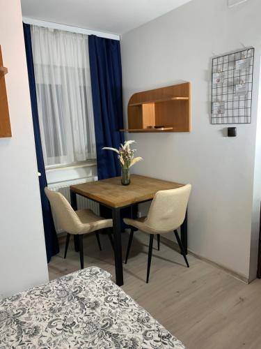 une chambre avec une table et deux chaises et une chambre avec un lit dans l'établissement Zacisze Nest - noclegi blisko plaży, à Mielno