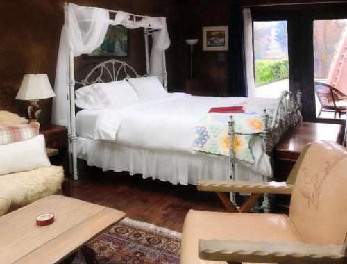 una camera con un letto bianco e una sedia di DunMovin’ Oregon a Grants Pass