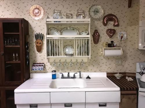 a kitchen with a white sink and plates on the wall at DunMovin’ Oregon in Grants Pass