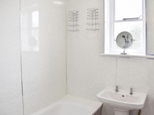 baño con lavabo y aseo y ventana en Delmonte, en Langwathby