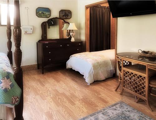 a bedroom with a bed and a desk and a mirror at DunMovin’ Oregon in Grants Pass