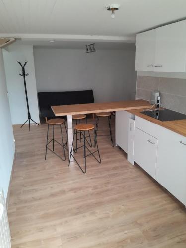 cocina con mesa y taburetes en una habitación en studio des Castors, en Condrieu