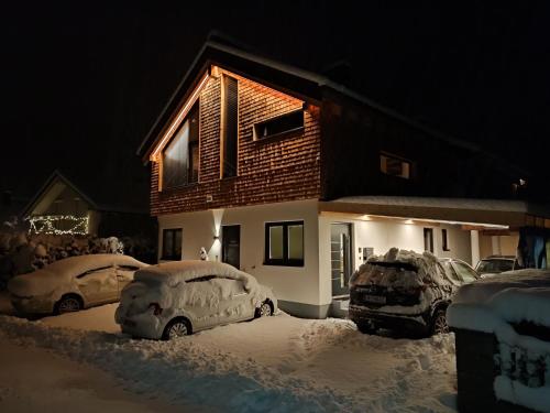 a house with cars covered in snow in front of it at Mountain alpine in Kappl