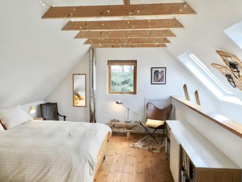 een slaapkamer met een groot bed op zolder bij Baltinna East - by Where Stags Roar in Newtonmore