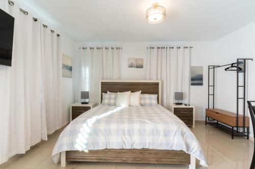 a bedroom with a large bed with white curtains at Aquaville Dorado Moderna Studio 6 in Dorado