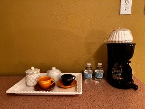 uma bandeja com chávenas e chávenas num balcão com comodidades para preparar café em Nice room near UCF em Orlando