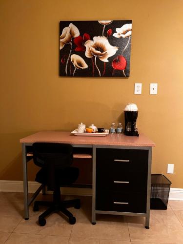 a desk with a chair and a painting on the wall at Nice room near UCF in Orlando