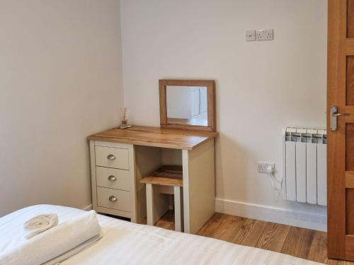 a bedroom with a dressing table and a mirror at Berts Bothy in Threlkeld