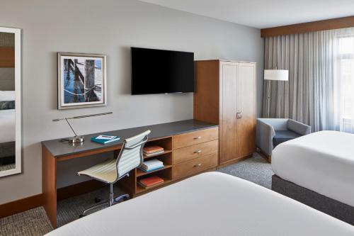 Habitación de hotel con escritorio y cama en The Hotel Landing, en Wayzata