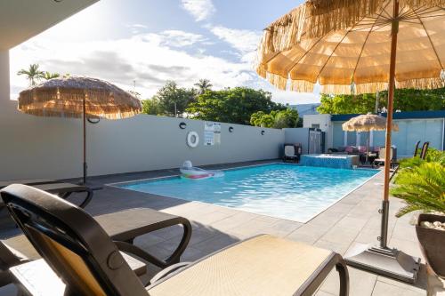 a pool with chairs and umbrellas on a patio at Aquaville Dorado Moderna Villa 3 in Dorado