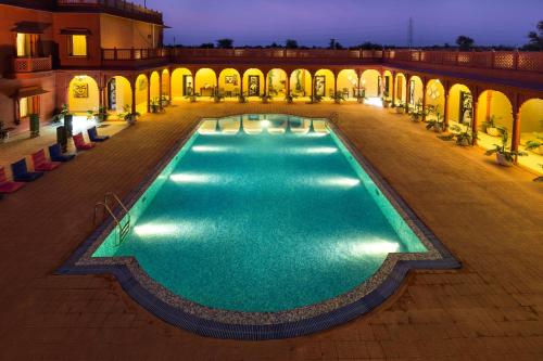 an empty pool in a courtyard at night at Vesta Bikaner Palace in Bikaner