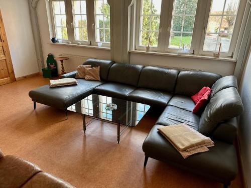 a living room with a leather couch and a coffee table at Großes Ferienhaus an der Ostsee "Oldevighus" in Hohenkirchen