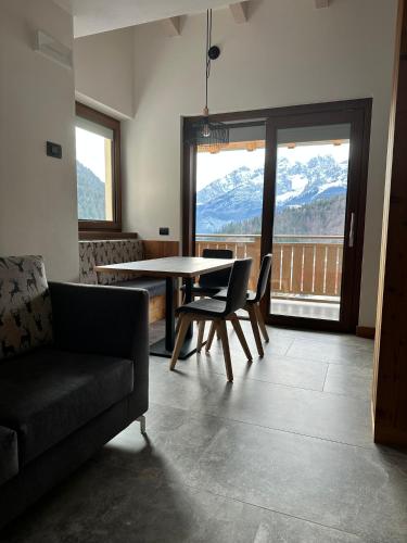 a living room with a table and chairs and a view at Al Marchior in Andalo