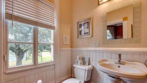 a bathroom with a sink and a toilet and a window at Forsyth Park 2 Bedroom Beauty in Savannah