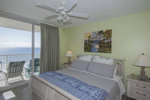 a bedroom with a bed and a balcony with the ocean at Beach Club C1001 Amazing Corner Unit in Gulf Shores