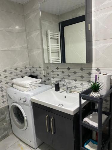 een badkamer met een wasmachine en een wastafel bij Nur-Ella House in Burunabat