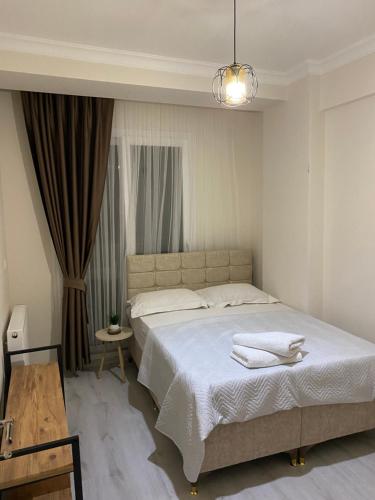 - une chambre avec un lit et des serviettes dans l'établissement Nur-Ella House, à Burunabat