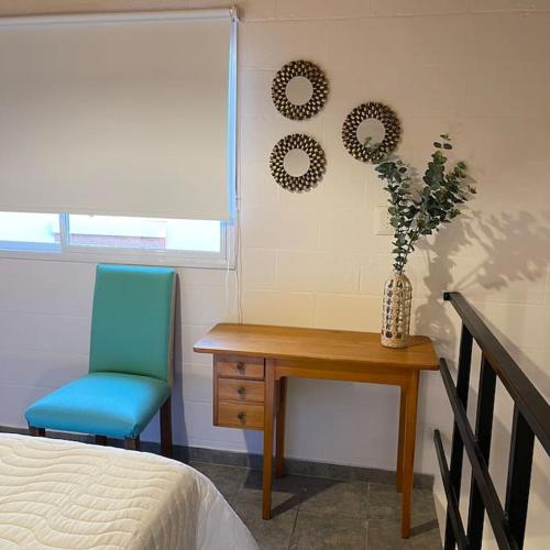 a bedroom with a desk and a blue chair and a table at Hermoso Depto en Comodoro! in Comodoro Rivadavia