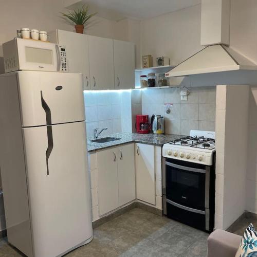 a kitchen with a white refrigerator and a stove at Hermoso Depto en Comodoro! in Comodoro Rivadavia
