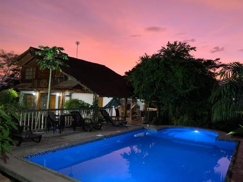 a blue swimming pool in front of a house at QUINTA VACACIONAL DIEGO ALFONSO, MY house in Macas in Macas
