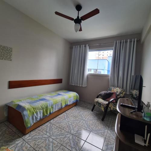 Schlafzimmer mit einem Bett, einem TV und einem Stuhl in der Unterkunft Apartamento Praia Coqueiral de Itaparica - Vila Velha in Vila Velha