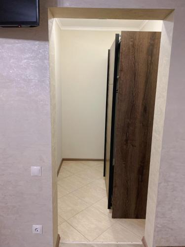 a refrigerator with a wooden door in a room at Вілла Aqua Shayan in Shaian