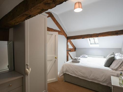 a bedroom with a bed and an open door at Grove Farm Cottage in Condover
