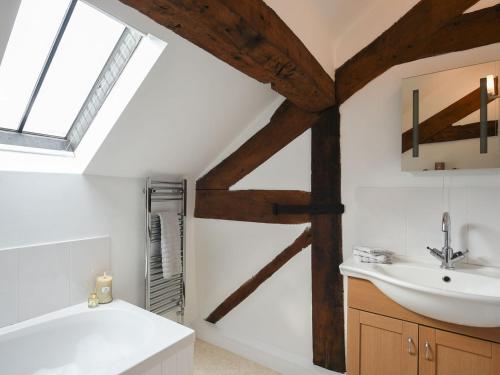 een badkamer met een wastafel, een bad en een wastafel bij Grove Farm Cottage in Condover