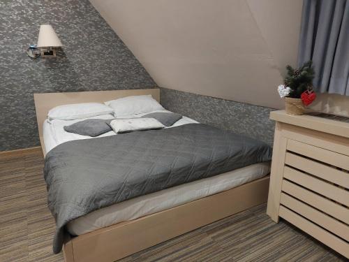 - une chambre avec un lit doté d'une couette et d'oreillers gris dans l'établissement Sweet Home Konaci, à Kopaonik