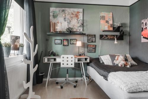 a bedroom with a bed and a desk in it at Guestly Homes - 4BR City Center Apartment in Piteå