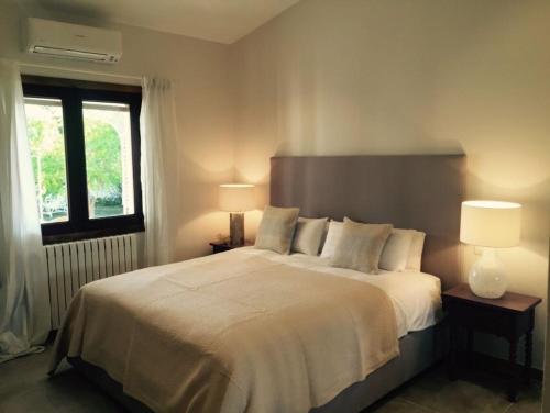 a bedroom with a large white bed with two lamps at Villa Can Llompart Port de Pollensa in El Port