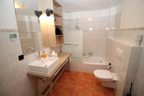 a bathroom with a sink and a toilet and a tub at Ferienwohnung Sonnen See in Ascheberg