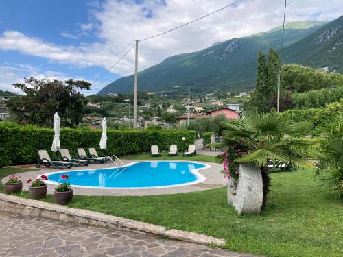 a swimming pool in a resort with mountains in the background at Apartments Panoramica in Malcesine