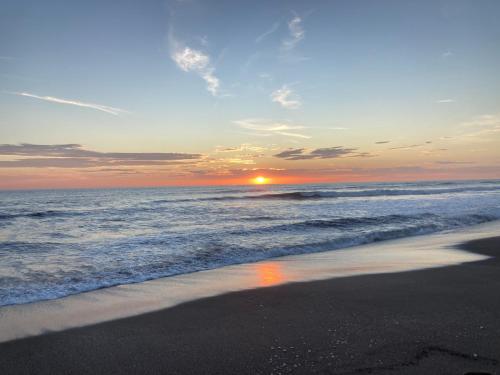 a sunset on a beach with the ocean at Hotel Tranquilo in Las Peñitas