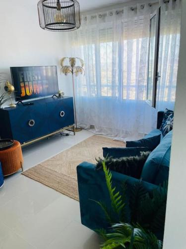 a living room with a blue couch and a tv at Couples Only, beautiful 1 Bedroom Apartment in Victoria Building in Mojácar